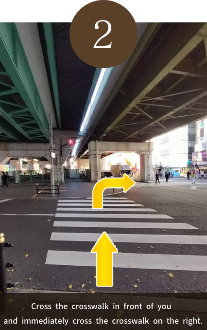 Cross the crosswalk in front of you and immediately cross the crosswalk on the right.